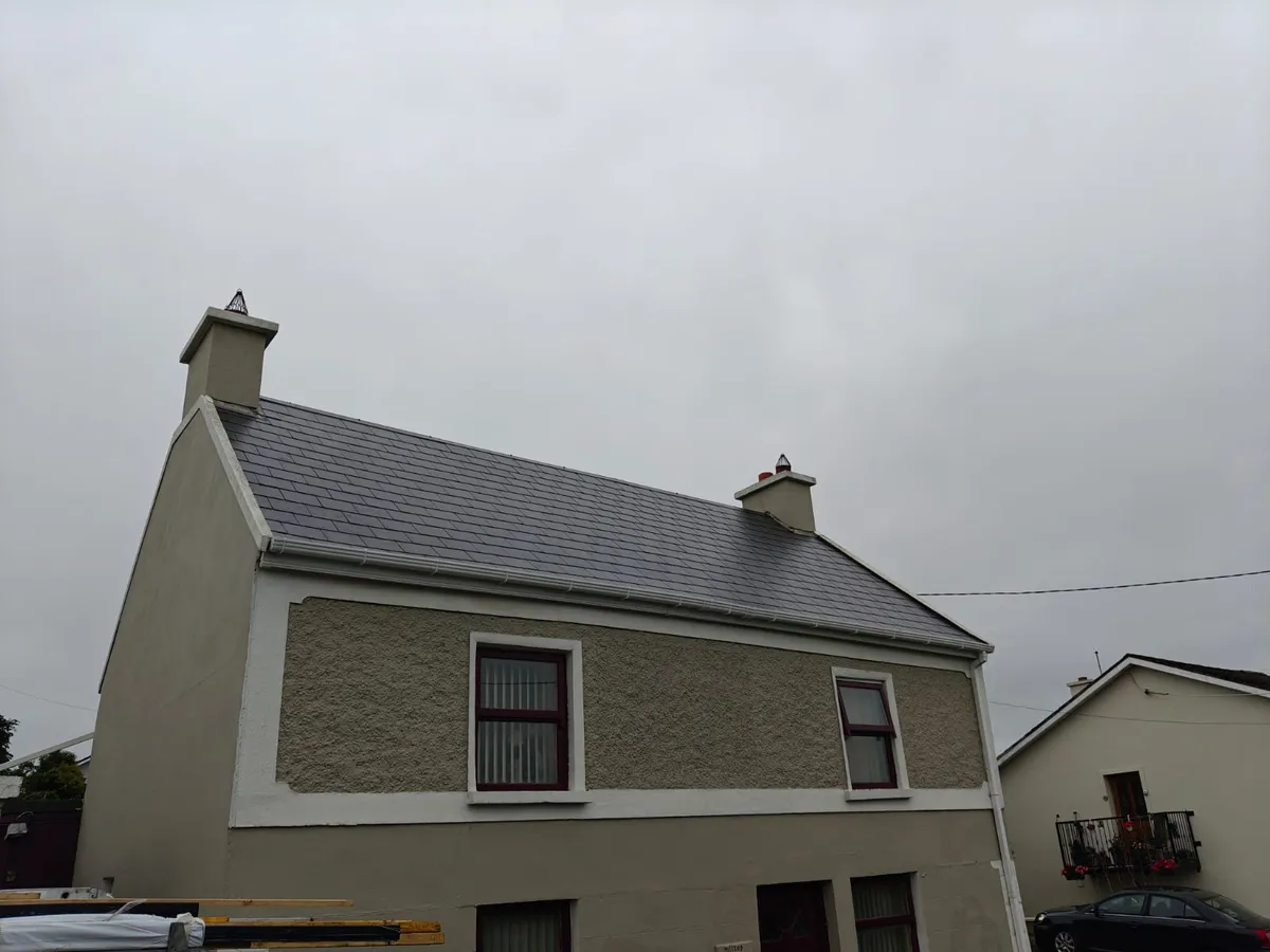 A house with a new natural slate roof and two chimney stacks